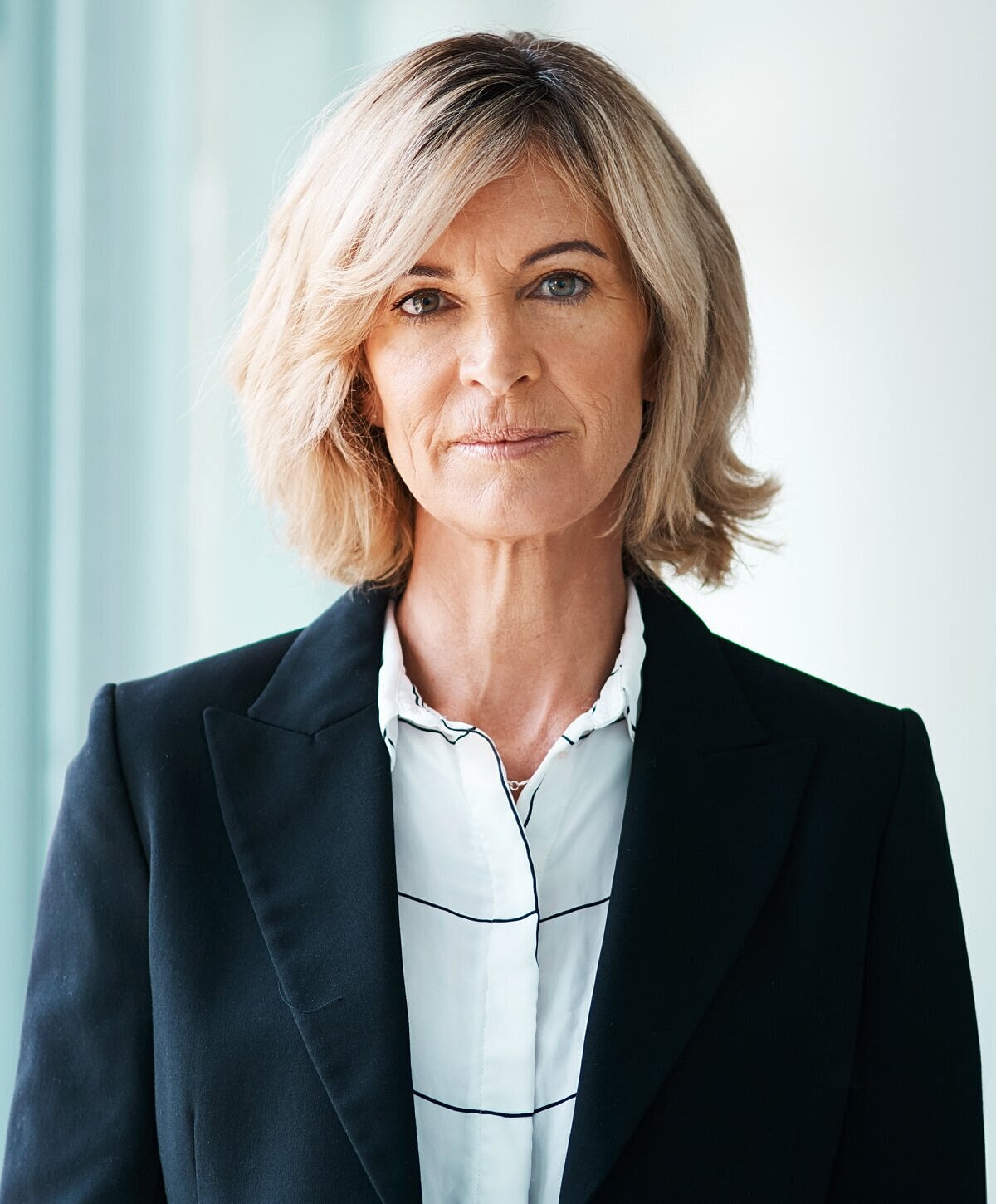 Woman with wavy hair and statement earrings.