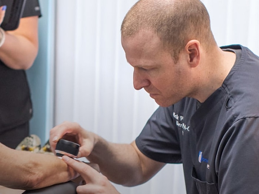 Medical professional examining patient’s arm.
