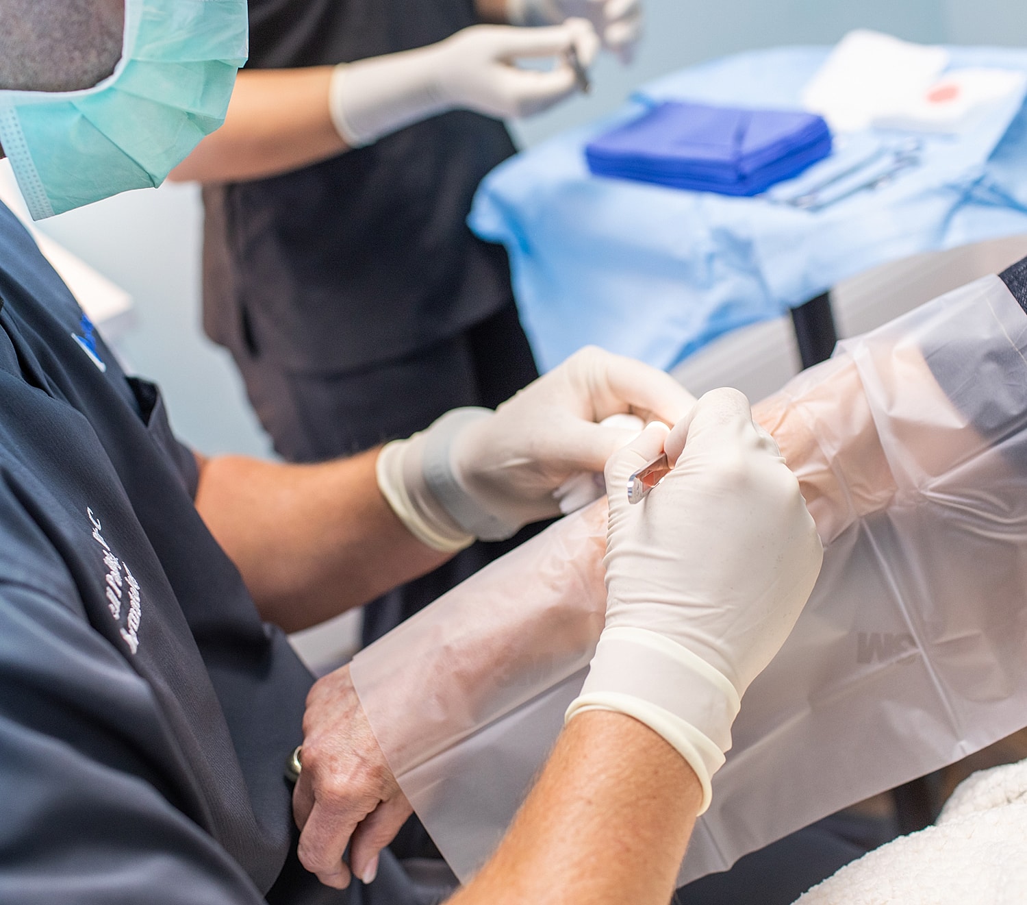Medical procedure involving gloved hands and patient care.