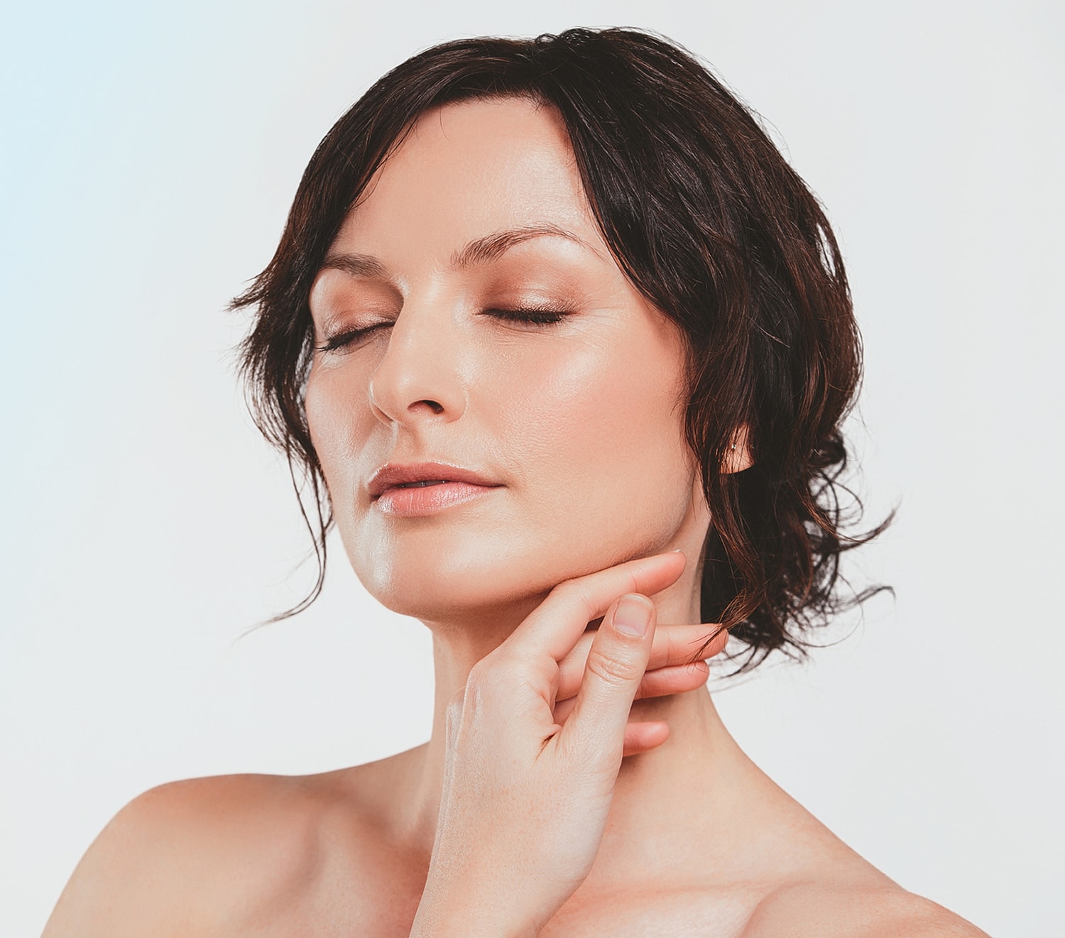 Woman with short hair posing gracefully and serene.