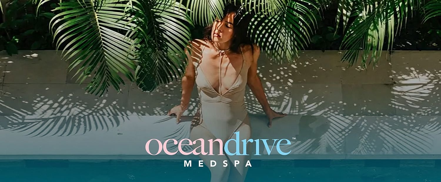 Woman posing near pool with tropical backdrop.