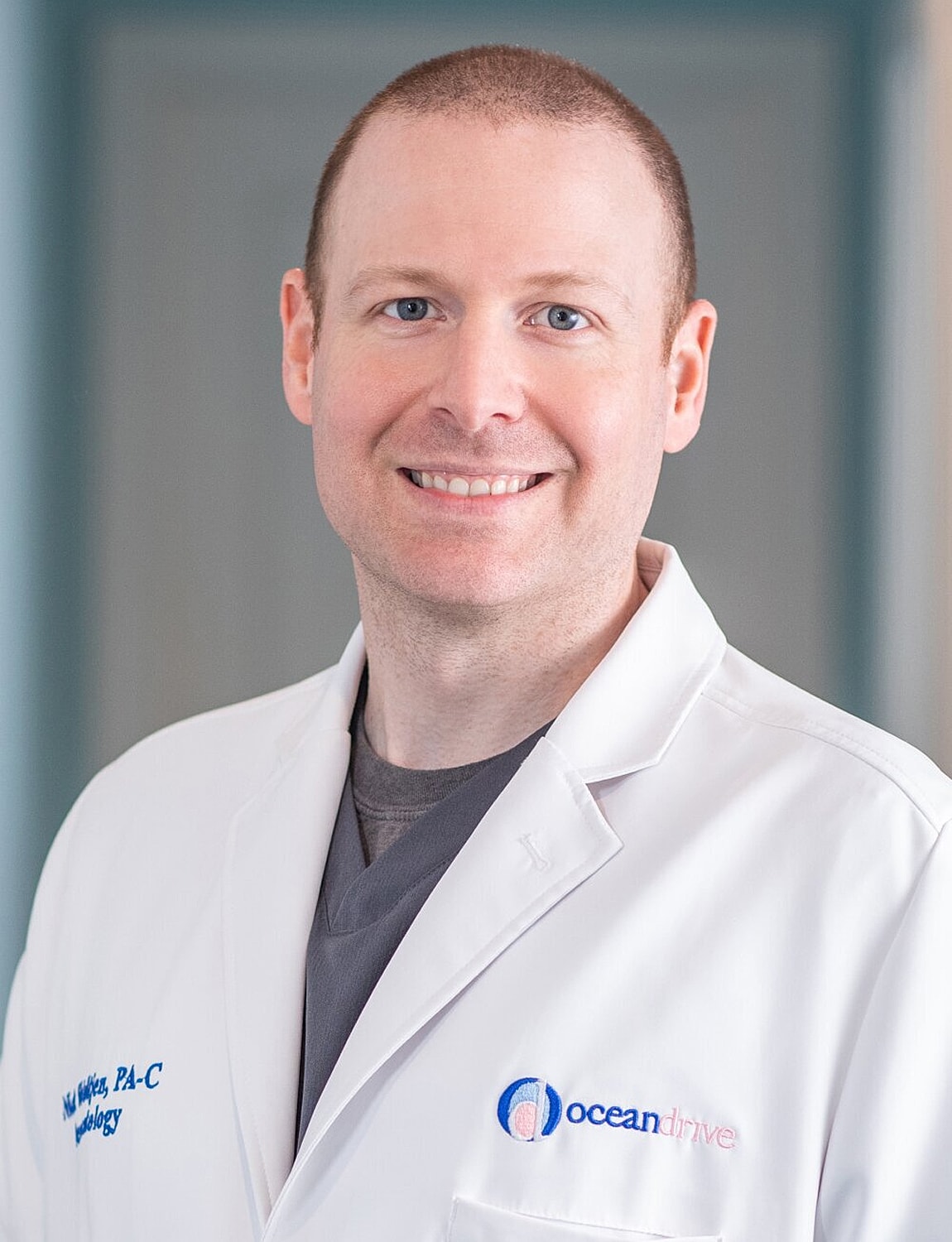 Smiling medical professional in white coat portrait.