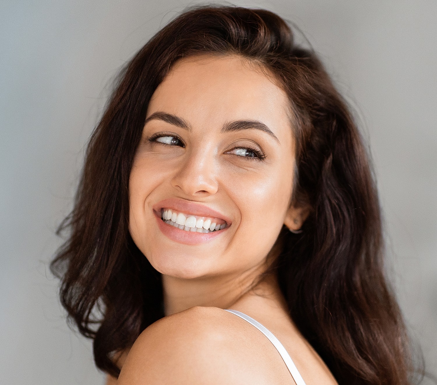 Smiling woman with dark hair and bright eyes.